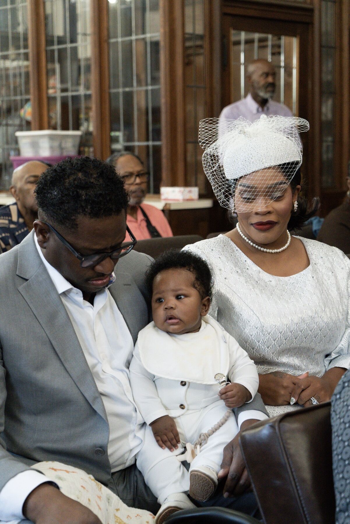 A family with their baby dressed in white at service