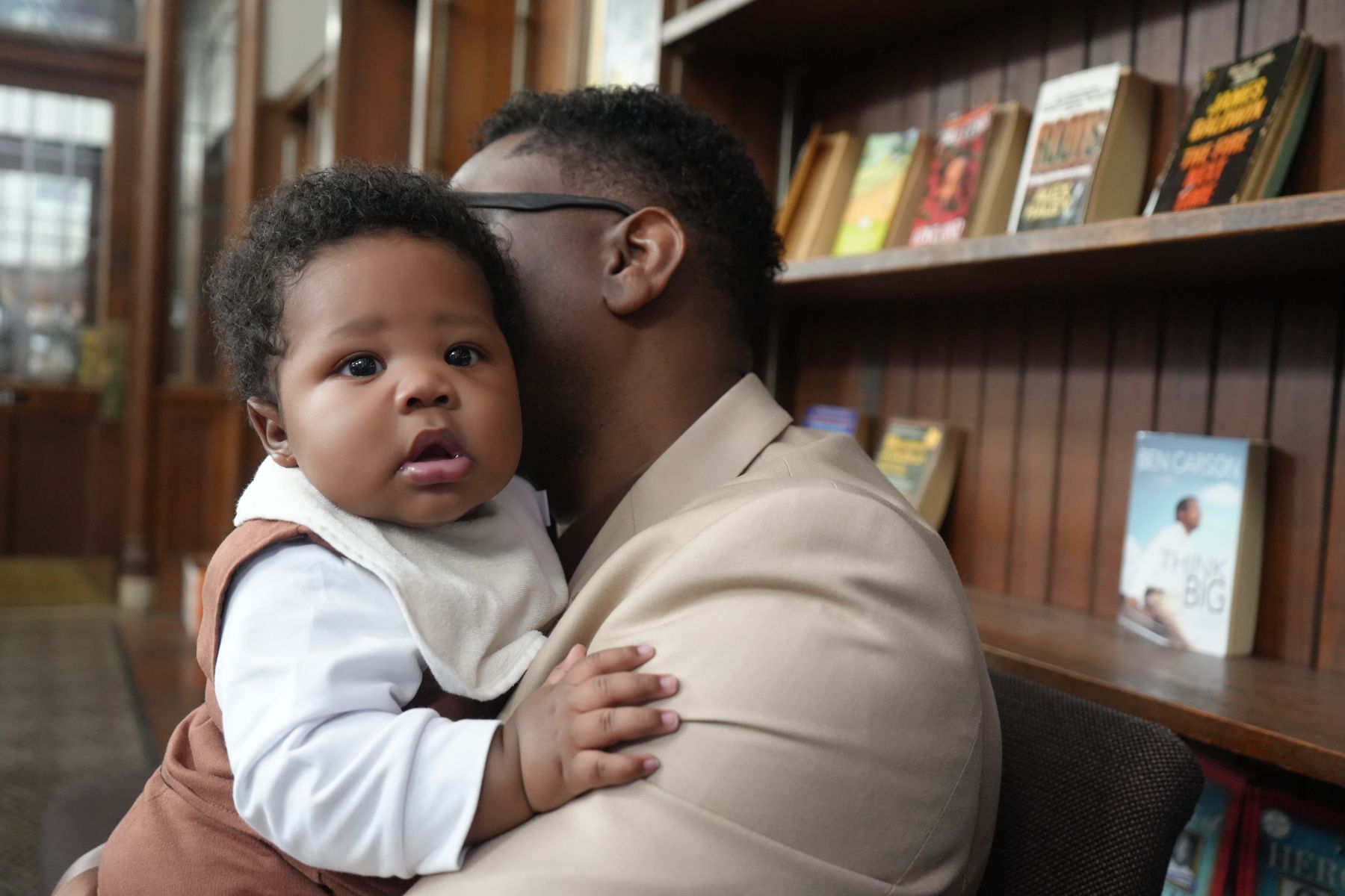 A father holding his baby in the Bridge Center library